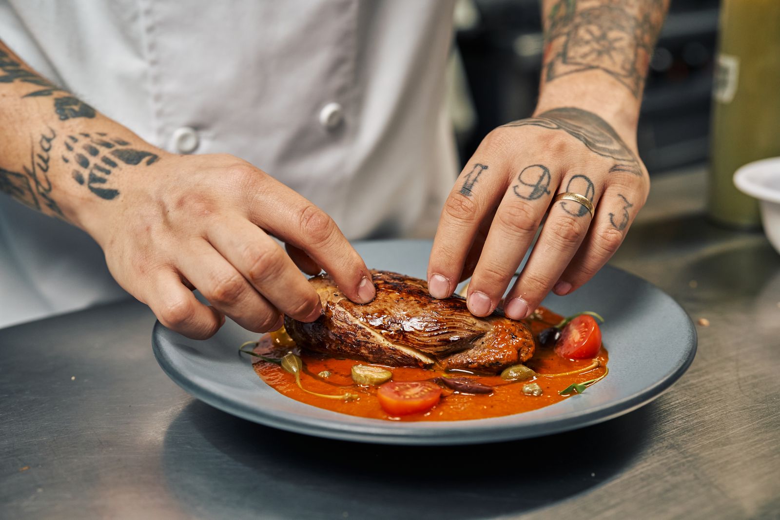 A caterer plating a gourmet dish at a catered event